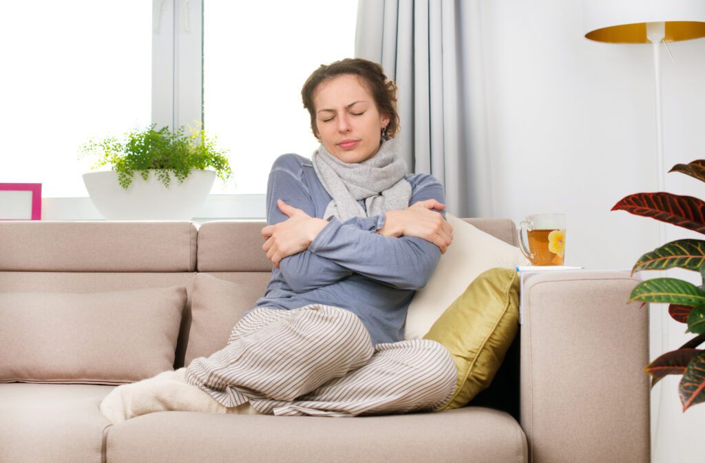 woman bundled up on couch 