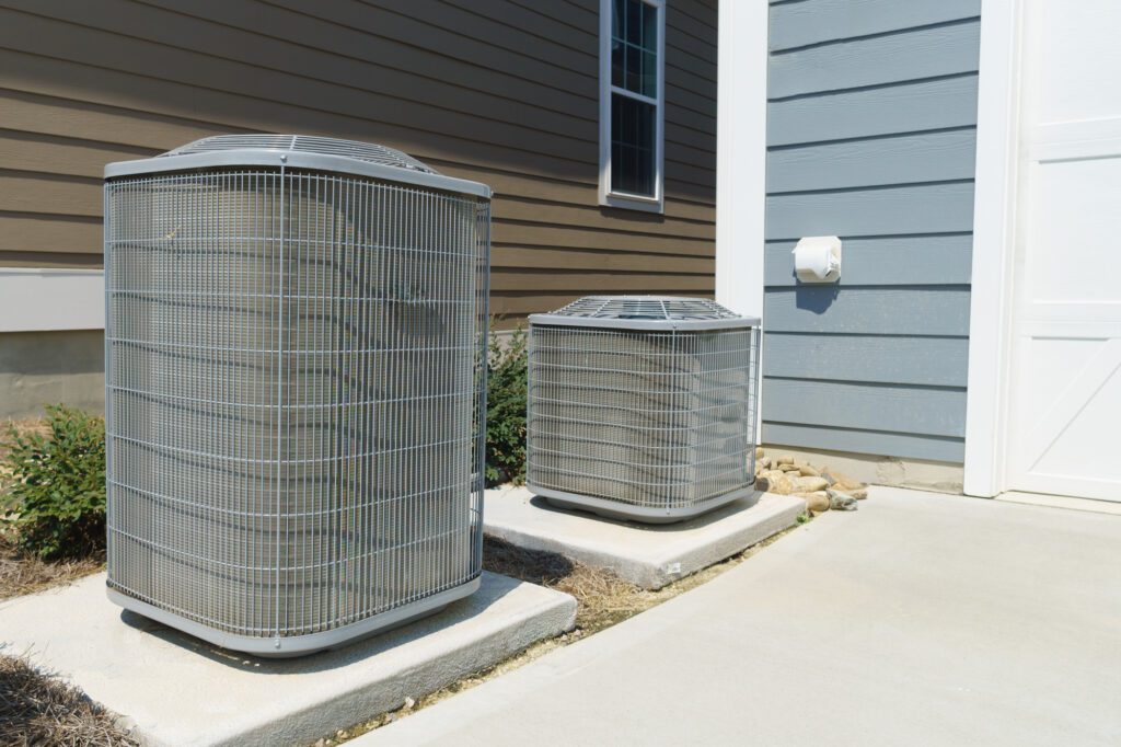 two hvac units sitting on concrete pads outside building